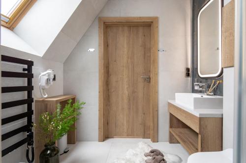 a bathroom with a wooden door and a sink at Villa 16 Zakopane in Zakopane