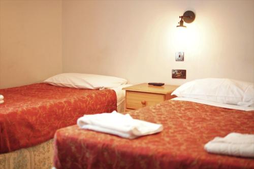 A bed or beds in a room at Plaza Hotel 