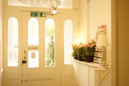 a white door with windows and flowers in a room at Plaza Hotel in London