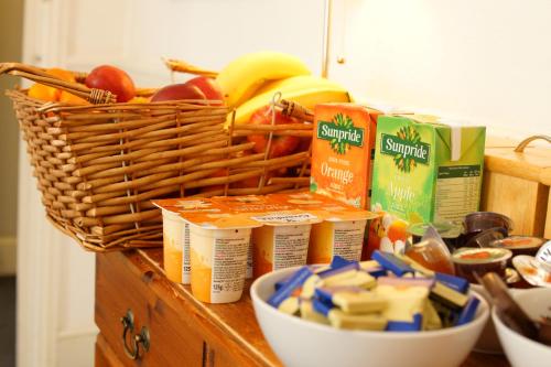 a counter with a basket of food and a bowl of cheese at Plaza Hotel in London