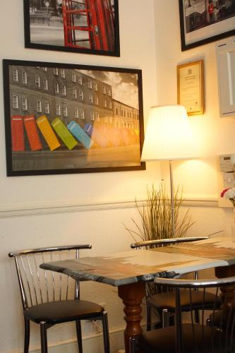 a dining room table with chairs and a lamp at Plaza Hotel in London
