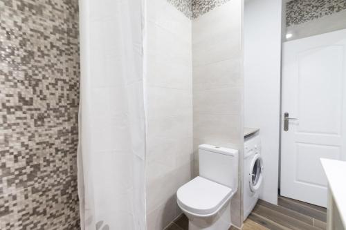 ein weißes Bad mit einem WC und einem Waschbecken in der Unterkunft Moonkey - Apartamento Amaralba B in Alicante