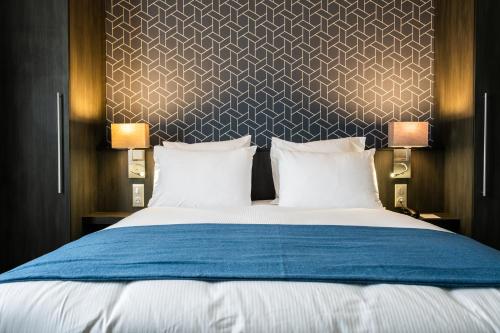 a bedroom with a large bed with two lamps at Best Western Plus Le Canard sur le Toit in Colomiers
