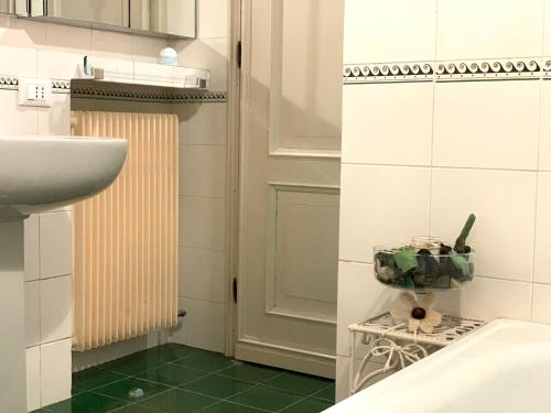 a bathroom with a sink and a toilet and green floor at Canal Riva De Biasio in Venice