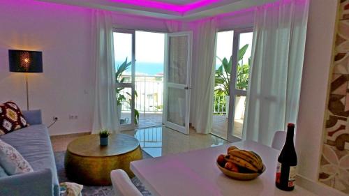 a living room with a table with a bowl of fruit on it at Sea Views and big balcony in Torremolinos