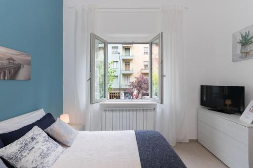 Schlafzimmer mit einem Bett und einem Fenster in der Unterkunft Studio Glicine by Wonderful Italy in Turin
