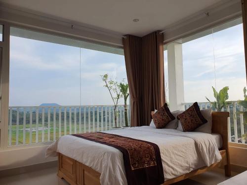 a bedroom with a bed and a large window at Minh Manh Hotel 2 in Pleiku