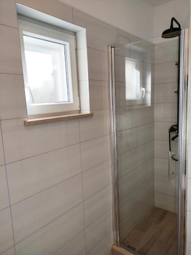 a bathroom with a shower with a window at Secluded Holiday home HERITAGE in Postira