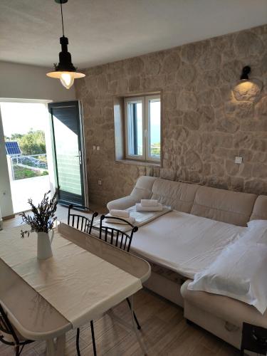a bedroom with a bed and a table and chairs at Secluded Holiday home HERITAGE in Postira