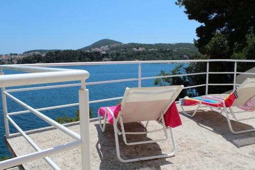 2 sillas sentadas en un balcón con vistas al agua en Apartments Lozica, en Dubrovnik