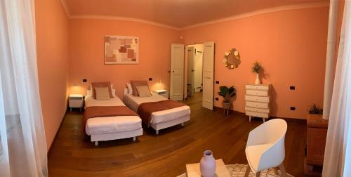 two beds in a bedroom with orange walls and wooden floors at Borgo La Morra in Pavullo nel Frignano