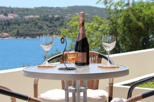 una botella de vino en una mesa con dos copas de vino en Apartments Lozica, en Dubrovnik