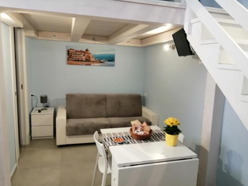 a small living room with a couch and a table at Domus Flò in Santa Maria di Castellabate