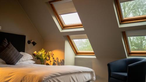 a bedroom with skylights and a bed and a chair at Crouchers Hotel in Chichester