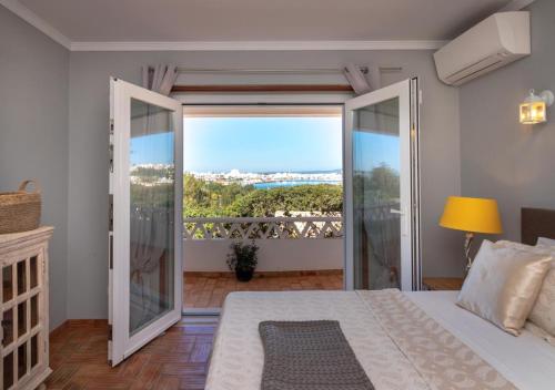 a bedroom with a bed and a balcony with a view at Villa Atlantic Blue Luxury with Ocean views in Ferragudo