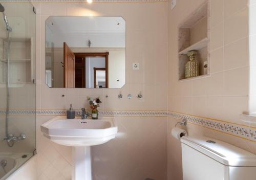 a bathroom with a sink and a mirror and a toilet at Villa Atlantic Blue Luxury with Ocean views in Ferragudo