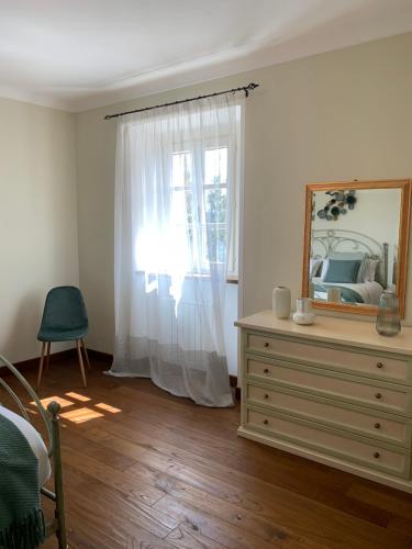 a bedroom with a dresser and a mirror and a window at Borgo La Morra in Pavullo nel Frignano