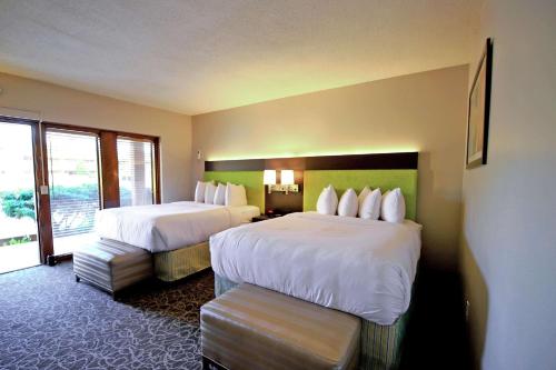a hotel room with two beds and a window at El Sendero Inn, an Ascend Collection Hotel in Santa Fe