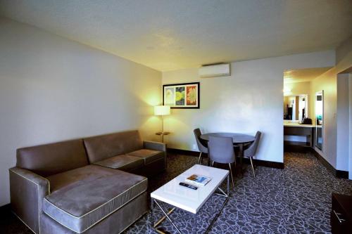 a living room with a couch and a table at El Sendero Inn, an Ascend Collection Hotel in Santa Fe
