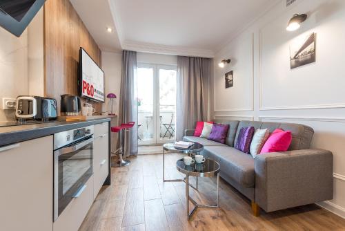 a living room with a couch and a kitchen at Plater & Poznanska Serviced Apartments in Warsaw