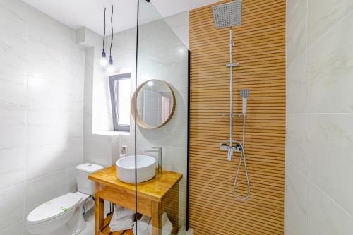 a bathroom with a sink and a shower with a mirror at Yael Luxury Apartments 4 in Buşteni