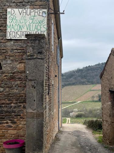 a building with a sign on the side of it at La Tablée Médiévale in Civrieux-dʼAzergues