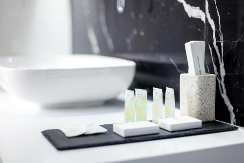 a black tray with toothbrushes on a bathroom counter at N Hotel BY NOSHI in Rinas