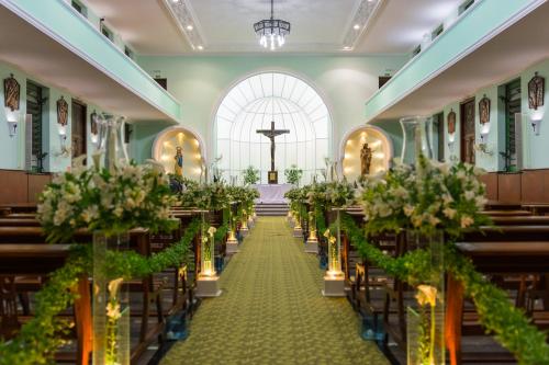 a row of pews in a church with flowers at Eventos & Hospedagem Sagrada Família in Sao Paulo