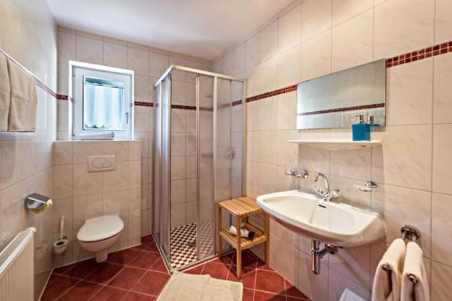 a bathroom with a sink and a shower and a toilet at Ferienwohnung Helena in Schwendau