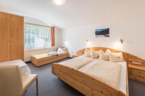 a bedroom with a large wooden bed and a couch at Ferienwohnung Helena in Schwendau