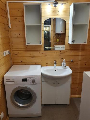 Un baño con lavadora y lavabo. en Domek Gucio, en Morąg