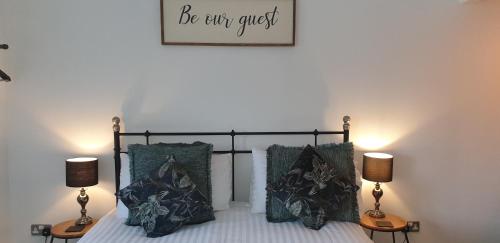 ein Schlafzimmer mit einem Bett mit zwei Lampen und einem Bild an der Wand in der Unterkunft Monkton Court House B&B in Honiton