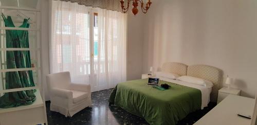 ein Schlafzimmer mit einem grünen Bett und einem Stuhl in der Unterkunft Aquarium by the Sea in Levanto
