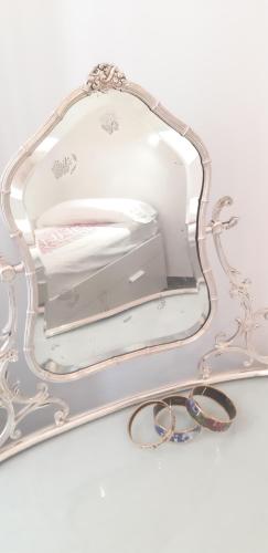 a mirror with a bed and a pair of glasses at Aquarium by the Sea in Levanto