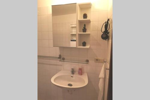 La salle de bains blanche est pourvue d'un lavabo et d'un miroir. dans l'établissement Easy comfort, à Bruxelles
