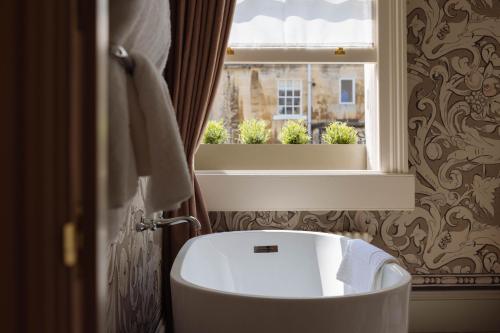 
a white bath tub sitting next to a window at The Yard in Bath Hotel in Bath
