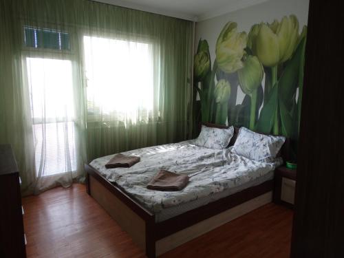 a bedroom with a bed with a flower mural on the wall at 2 Bedrooms with private Bath and balcony near the Airport in Sofia