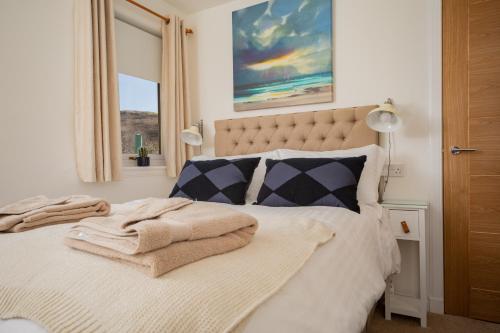 a bedroom with a bed with towels on it at Raasay@Knock View Apartments, Sleat, Isle of Skye in Teangue