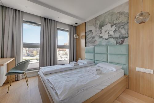 sypialnia z 2 łóżkami, biurkiem i oknem w obiekcie Grano Residence Comfort Apartments w Gdańsku