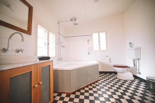 a bathroom with a tub and a sink and a toilet at Goat Square Cottages in Tanunda