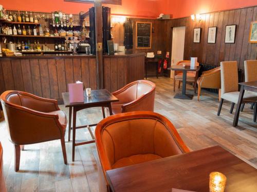 a restaurant with tables and chairs and a bar at Guyers House Hotel and Restaurant in Corsham