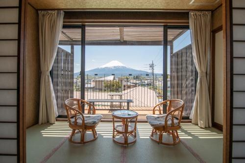 um quarto com uma varanda com vista para uma montanha em Tabist Fuji inn Ohashi Fujikawaguchiko em Fujikawaguchiko