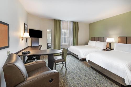 um quarto de hotel com duas camas e uma secretária em Candlewood Suites Hattiesburg, an IHG Hotel em Hattiesburg