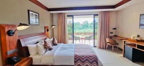 um quarto de hotel com uma cama e uma varanda em Kampala Nile Resort em Seeta