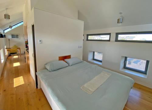 een slaapkamer met een groot wit bed en 3 ramen bij Kinvara Suites in Kinvara