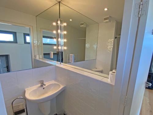 a white bathroom with a sink and a mirror at Kinvara Suites in Kinvara