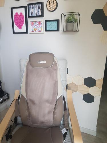 a chair in a room with pictures on the wall at gite A L' ÉVIDENCE in Mornas