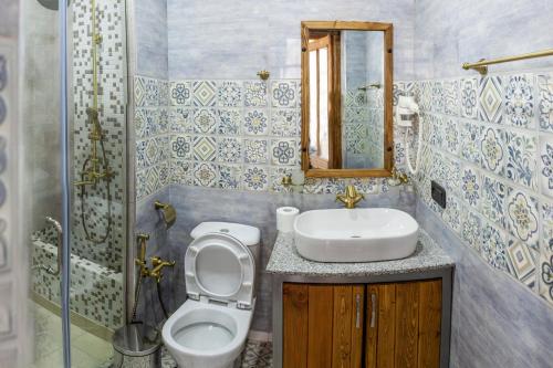 a bathroom with a sink and a toilet and a mirror at ARmoon Hotel in Gyumri