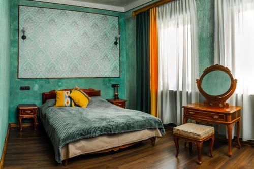 Schlafzimmer mit grünen Wänden und einem Bett mit Spiegel in der Unterkunft ARmoon Hotel in Gjumri