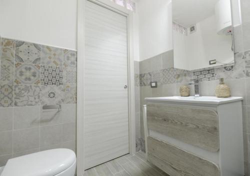 een witte badkamer met een toilet en een wastafel bij Casa Vacanza Zeus in Noto